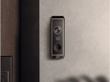 Charger l&#39;image dans la galerie, Sonnette vidéo Eufy noire sur un mur gris. Caméra, bouton et haut-parleur visibles.
