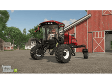 Charger l&#39;image dans la galerie, Un tracteur rouge dans un champ. Une personne est dans la cabine. Il y a une grange rouge en arrière-plan.
