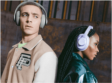 Charger l&#39;image dans la galerie, Un homme et une femme portent un casque audio, dos à dos. Le fond est sombre.
