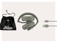 Charger l&#39;image dans la galerie, Casque plié, un sac noir et deux câbles sur une surface blanche. Texte sur le sac.
