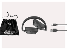 Charger l&#39;image dans la galerie, Casque noir, un sac de transport et deux câbles de charge sur une surface blanche.
