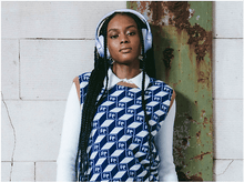 Charger l&#39;image dans la galerie, Une femme portant un casque violet et un gilet à motifs bleus et blancs.
