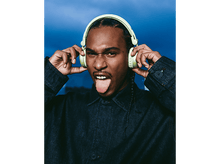 Charger l&#39;image dans la galerie, Un homme avec un casque vert, tirant la langue, portant une veste en jean.
