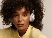 Charger l&#39;image dans la galerie, Jeune femme avec un casque violet. Elle porte une chemise jaune et le fond est neutre.
