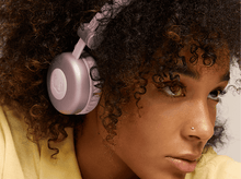 Charger l&#39;image dans la galerie, Femme aux cheveux bouclés portant un casque rose, gros plan, chemise jaune.
