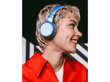 Charger l&#39;image dans la galerie, Femme avec un casque bleu souriante. Elle porte une veste rouge. Fond à rayures noires et blanches.
