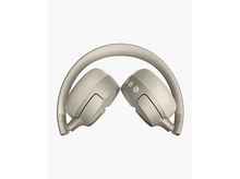 Charger l&#39;image dans la galerie, Paire d&#39;écouteurs beiges, pliés en deux, sur fond blanc. Les écouteurs sont tournés vers l&#39;arrière.
