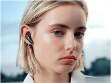 Charger l&#39;image dans la galerie, Femme avec écouteur dans l&#39;oreille, regardant la caméra, arrière-plan flou.
