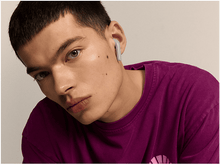 Charger l'image dans la galerie, Gros plan d'un jeune homme avec un t-shirt violet et un écouteur lavande à l'oreille.
