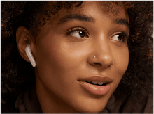 Charger l'image dans la galerie, Gros plan d'une femme aux cheveux bruns avec des écouteurs roses, regardant en haut à droite.
