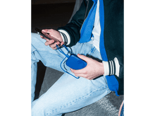 Charger l'image dans la galerie, Une personne tient une batterie externe bleue et un téléphone.
