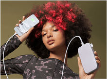 Charger l'image dans la galerie, Une femme tenant un téléphone en charge et une batterie externe, tous deux avec un design marbré, fond vert.

