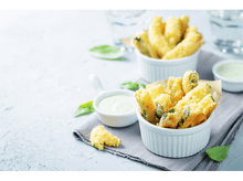 Charger l&#39;image dans la galerie, Bâtonnets de courgettes frits dans des bols avec sauce, feuilles de basilic sur surface claire.
