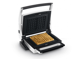 Gaufrier ouvert avec deux gaufres. Appareil argenté et noir avec gaufre noire.