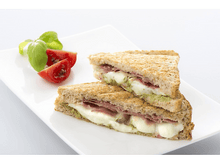 Charger l&#39;image dans la galerie, Deux sandwichs au pesto, jambon et mozzarella sur une assiette blanche.
