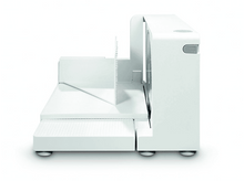 Charger l&#39;image dans la galerie, Une trancheuse à aliments blanche sur une surface blanche. Elle possède une lame et un chariot à aliments.
