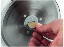 Charger l&#39;image dans la galerie, Une main insérant une pièce dans une fente. La pièce est une pièce de deux euros.
