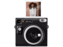 Charger l&#39;image dans la galerie, Appareil photo Instax SQ40 noir avec photo d&#39;une femme souriante aux cheveux bouclés.
