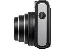 Charger l&#39;image dans la galerie, Vue latérale d&#39;un appareil photo argenté et noir. L&#39;objectif est à gauche, le bouton d&#39;alimentation à droite.
