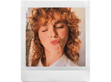Charger l&#39;image dans la galerie, Photo de style Polaroid d&#39;une femme aux cheveux roux bouclés, les yeux fermés, faisant une moue de baiser.
