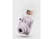 Charger l&#39;image dans la galerie, Un appareil photo Instax violet éjectant une photo, sur fond blanc.
