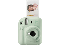 Appareil photo Instax i12 vert menthe avec une photo imprimée. Fond noir.