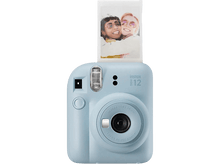 Charger l&#39;image dans la galerie, Appareil photo Instax i12 bleu clair. Une photo avec deux femmes souriantes est éjectée. Fond noir.
