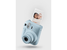 Charger l&#39;image dans la galerie, Un appareil photo Instax bleu clair avec une photo montrant deux femmes souriantes.

