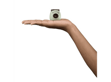 Charger l&#39;image dans la galerie, Un petit appareil photo vert tenu dans une main sur fond blanc.
