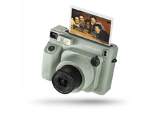 Charger l&#39;image dans la galerie, Un appareil photo Instax Wide 400 vert clair avec une photo de personnes, sur fond blanc.
