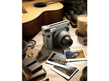 Charger l&#39;image dans la galerie, Un appareil photo avec des photos sur une table, avec une guitare, du café et d&#39;autres objets. L&#39;appareil photo est vert clair.
