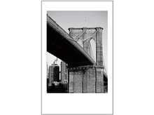 Charger l&#39;image dans la galerie, Photo en noir et blanc. Arches du pont de Brooklyn en vue, avec paysage urbain en arrière-plan. Ciel clair.
