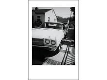 Charger l&#39;image dans la galerie, Photo en noir et blanc d&#39;une voiture classique garée dans une allée, devant une maison.
