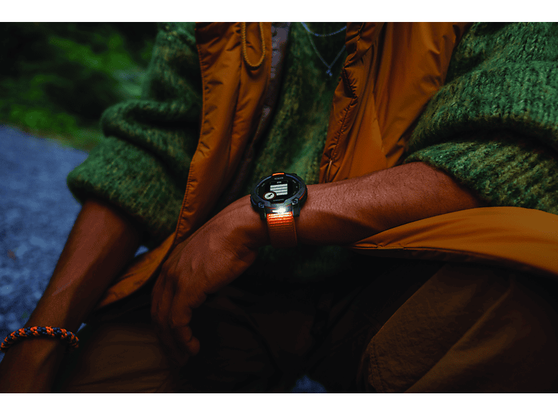 Personne portant une smartwatch, affichant l'heure, devant un fond vert flou.