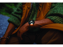 Charger l&#39;image dans la galerie, Personne portant une smartwatch, affichant l&#39;heure, devant un fond vert flou.
