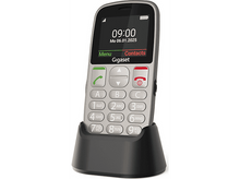 Charger l&#39;image dans la galerie, Un téléphone Gigaset argenté affiche l&#39;heure et la date. Il repose sur une base de chargement noire. Les boutons et un écran sont visibles.
