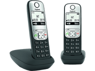 Deux téléphones sans fil, un sur socle. Les deux ont des écrans affichant l'heure et un menu.