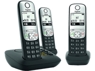 Trois téléphones sans fil noirs et argentés sur un chargeur. Chaque téléphone affiche l'heure et la date.