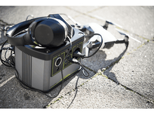 Charger l&#39;image dans la galerie, Une station d&#39;alimentation portable avec un casque, un drone et des câbles sur une surface en béton.
