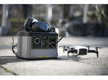 Charger l&#39;image dans la galerie, Une centrale électrique avec un casque et un drone. La scène est en extérieur.
