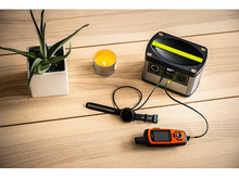 Charger l&#39;image dans la galerie, Une plante, une bougie et une station d&#39;alimentation portable sur une table en bois, avec une montre connectée et GPS.
