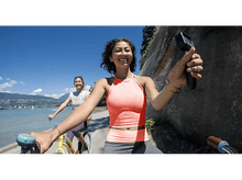 Charger l&#39;image dans la galerie, Deux femmes font du vélo par une journée ensoleillée. L&#39;une tient une caméra.
