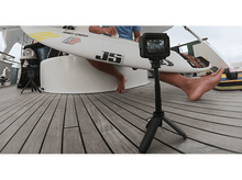 Charger l&#39;image dans la galerie, Un surfeur avec une planche de surf sur un yacht, filmé par une GoPro sur un trépied.
