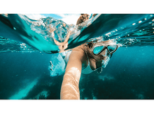 Charger l'image dans la galerie, Une personne faisant de la plongée avec tuba dans une eau claire, gros plan sur la personne dans l'eau.
