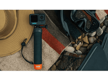 Charger l'image dans la galerie, Caméra GoPro sur une poignée, équipement de plongée et un chapeau sur une couverture à motifs, sur fond blanc.

