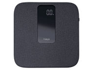 Balance numérique avec affichage numérique indiquant 0,0 kg. Tissu gris avec le logo Haepi.