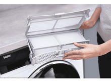 Charger l&#39;image dans la galerie, Personne tenant un filtre blanc d&#39;une machine à laver. La machine est blanche.
