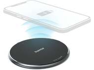 Chargeur sans fil avec téléphone dessus. Le chargeur est noir et le téléphone blanc.