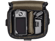 Charger l&#39;image dans la galerie, À l&#39;intérieur d&#39;un sac photo vert, un appareil photo, un chargeur et un câble d&#39;alimentation.
