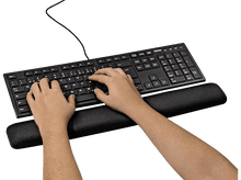 Charger l&#39;image dans la galerie, Mains tapant sur un clavier noir avec un repose-poignet. Le clavier est sur une surface blanche.
